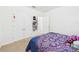 This bedroom offers a closet with double doors and neutral-colored carpeting throughout at 5751 Lakeside Landings Blvd, Winter Haven, FL 33881
