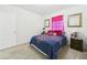 Cozy bedroom featuring bright pink curtains, bedside table, and neutral carpeting at 5751 Lakeside Landings Blvd, Winter Haven, FL 33881