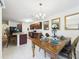 Dining area with open floor plan to kitchen, lovely table, and three mirrors at 5751 Lakeside Landings Blvd, Winter Haven, FL 33881