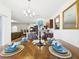 Dining table set for dinner with a view into kitchen and living room at 5751 Lakeside Landings Blvd, Winter Haven, FL 33881