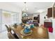 Dining area with a view to a kitchen, set table and sliding doors to a patio at 5751 Lakeside Landings Blvd, Winter Haven, FL 33881