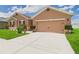 Spacious driveway leading to a two-car garage, complemented by manicured landscaping and a well-kept lawn at 5751 Lakeside Landings Blvd, Winter Haven, FL 33881