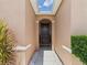 Charming front entryway with a dark wood door, decorative plants, and a well-lit porch at 5751 Lakeside Landings Blvd, Winter Haven, FL 33881