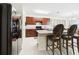 Updated kitchen featuring dark wood cabinetry, a breakfast bar, and modern appliances, with barstool seating at 5751 Lakeside Landings Blvd, Winter Haven, FL 33881