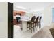 Modern kitchen with dark cabinets, breakfast bar seating, and stainless steel appliances at 5751 Lakeside Landings Blvd, Winter Haven, FL 33881