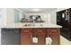 Kitchen island with sink, dishwasher, and dark wooden cabinets at 5751 Lakeside Landings Blvd, Winter Haven, FL 33881