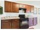 Cozy kitchen features wooden cabinets and black appliances at 5751 Lakeside Landings Blvd, Winter Haven, FL 33881