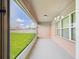 View of covered patio with screen, overlooking landscaped backyard and bright blue sky at 5751 Lakeside Landings Blvd, Winter Haven, FL 33881