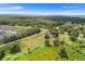 Aerial view showcasing a home on a large lot with mature trees and open green space under a clear sky at 5820 E Johnson Ave, Haines City, FL 33844