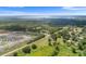 Expansive aerial view of a property with lush greenery, a home, and surrounding neighborhood near a lake at 5820 E Johnson Ave, Haines City, FL 33844