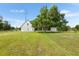 Backyard view with a large tree in the lawn in front of a screened-in porch at 5820 E Johnson Ave, Haines City, FL 33844