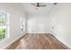 Bright bedroom with hardwood floors, ceiling fan, and natural light from two large windows at 5820 E Johnson Ave, Haines City, FL 33844