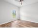 This bedroom boasts hardwood floors, a ceiling fan, and a window offering natural light at 5820 E Johnson Ave, Haines City, FL 33844