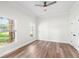 Bright bedroom featuring hardwood floors, two windows and a ceiling fan at 5820 E Johnson Ave, Haines City, FL 33844