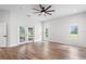 Well-lit bedroom with hardwood floors, ceiling fan and double french doors at 5820 E Johnson Ave, Haines City, FL 33844