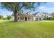 Beautiful home features a lush green lawn, charming porch with wooden pillars, and an attached garage at 5820 E Johnson Ave, Haines City, FL 33844