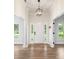 Bright and inviting foyer with a modern light fixture, white door, and wood-look floors at 5820 E Johnson Ave, Haines City, FL 33844