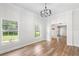 Bright living room featuring hardwood floors, a modern chandelier, and large windows with outdoor views at 5820 E Johnson Ave, Haines City, FL 33844