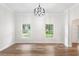 Bright living room with hardwood floors, a modern chandelier, and large windows offering natural light at 5820 E Johnson Ave, Haines City, FL 33844
