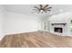 Bright living room with a cozy stone fireplace, hardwood floors, and a ceiling fan at 5820 E Johnson Ave, Haines City, FL 33844