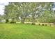 Large, well-maintained backyard with mature trees, a swing set, and a fenced perimeter for privacy and security at 6028 Hillside Heights Dr, Lakeland, FL 33812