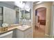 Bathroom vanity with white sink and archway to the room, showing neutral walls at 6028 Hillside Heights Dr, Lakeland, FL 33812