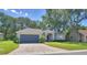 Inviting home featuring a two-car garage, a well-kept lawn, and mature trees for added curb appeal at 6028 Hillside Heights Dr, Lakeland, FL 33812