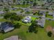 Aerial view of a residential property with a neatly landscaped yard and a charming home surrounded by lush greenery at 6192 Magpie Dr, Lakeland, FL 33809