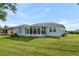 Backyard view of home featuring Florida room, well-kept lawn and landscaping at 6192 Magpie Dr, Lakeland, FL 33809