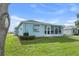 Backyard view of home featuring Florida room, well-kept lawn and landscaping at 6192 Magpie Dr, Lakeland, FL 33809