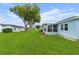 Lush backyard with well-maintained lawn, mature trees, and a covered patio, perfect for outdoor enjoyment at 6192 Magpie Dr, Lakeland, FL 33809