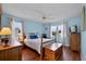 Bright bedroom with wooden floors, two windows, and a ceiling fan at 6192 Magpie Dr, Lakeland, FL 33809