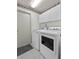 Bright laundry room with white cabinets, modern washer and dryer, and tiled floor for easy cleaning at 6192 Magpie Dr, Lakeland, FL 33809