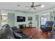 Cozy living room showcasing hardwood floors, a ceiling fan, comfortable seating, and access to other rooms at 6192 Magpie Dr, Lakeland, FL 33809