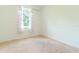 A bright bedroom with a window dressed with patterned curtains and neutral carpet at 6300 Dolostone Dr, Lakeland, FL 33811