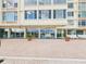 Exterior of building with patio, sliding glass doors, brick pavers, seating, and potted plants at 700 Mirror Nw Ter # 702, Winter Haven, FL 33881