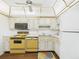 Well-lit kitchen with a retro yellow stove, white cabinets and good storage at 700 Mirror Nw Ter # 702, Winter Haven, FL 33881