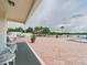 A view from the veranda that includes the swimming pool and relaxation area with palm trees and lounging furniture at 700 Mirror Nw Ter # 702, Winter Haven, FL 33881