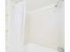 Clean, tiled shower stall with white shower curtain and updated fixtures in a bright, well-maintained bathroom at 700 Mirror Nw Ter # 702, Winter Haven, FL 33881
