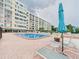 Community pool with lounge chairs and an adjacent multi-story building at 700 Mirror Nw Ter # 702, Winter Haven, FL 33881