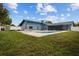 Expansive backyard featuring a pool, lush lawn, and a charming home exterior, ideal for outdoor living at 704 Butternut Pl, Lakeland, FL 33813