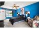 Bright bedroom with blue walls, ceiling fan, and view of the backyard pool at 704 Butternut Pl, Lakeland, FL 33813