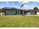 Landscaped front yard featuring a flagpole, walkway, and well-maintained lawn at 704 Butternut Pl, Lakeland, FL 33813