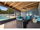 Covered patio with comfortable wicker furniture overlooking the pool and backyard at 704 Butternut Pl, Lakeland, FL 33813