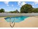 Sparkling pool with a lush backyard surrounded by a white fence, perfect for relaxation and privacy at 704 Butternut Pl, Lakeland, FL 33813