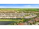 Expansive aerial view showcasing a neighborhood with a large green field and community pool at 7247 Oakmoss Loop, Davenport, FL 33837