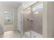 Bathroom with large glass shower and window with view to an adjacent bedroom at 7247 Oakmoss Loop, Davenport, FL 33837
