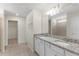 Bright bathroom featuring double vanity with granite counter and tile flooring at 7247 Oakmoss Loop, Davenport, FL 33837
