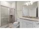Bathroom with tile shower, granite countertop, and white vanity at 7247 Oakmoss Loop, Davenport, FL 33837