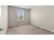 Cozy bedroom with neutral carpet and walls, and a window providing natural light at 7247 Oakmoss Loop, Davenport, FL 33837